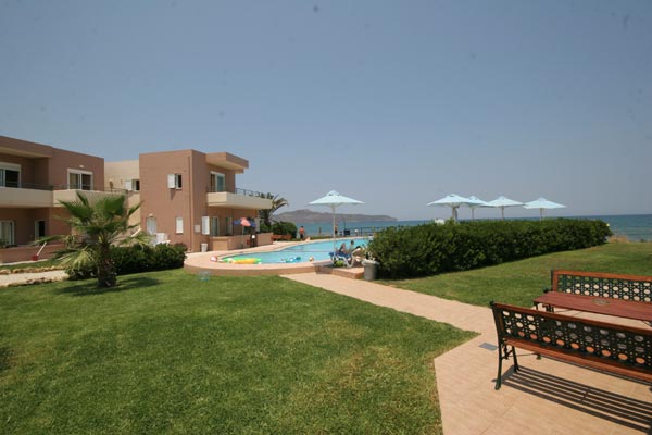 View from the room balcony of Phaedra  Hotel featuring the swimming pool and the  sandy beach of Kato Stalos also you can see the little island of Theodorou